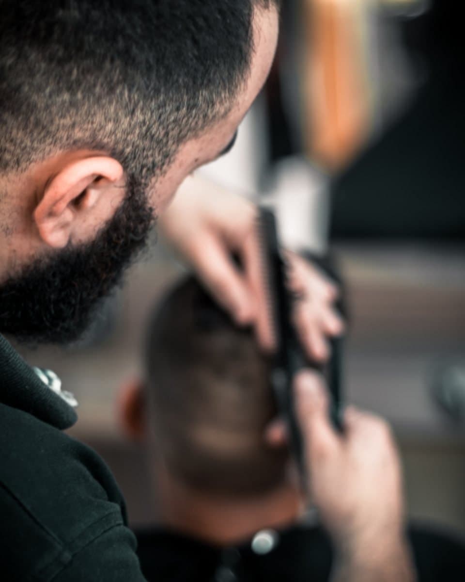Barber trimming a man's hair with clippers