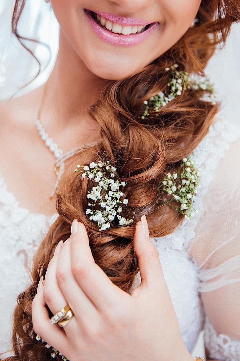 Smiling bride with a braided hairstyle and flowers