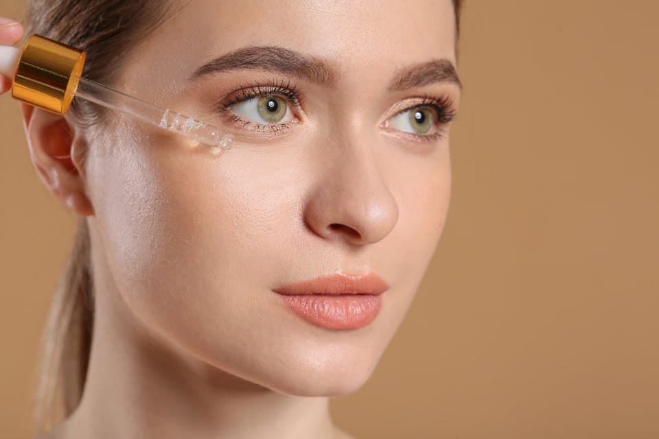 Woman applying facial serum with a dropper
