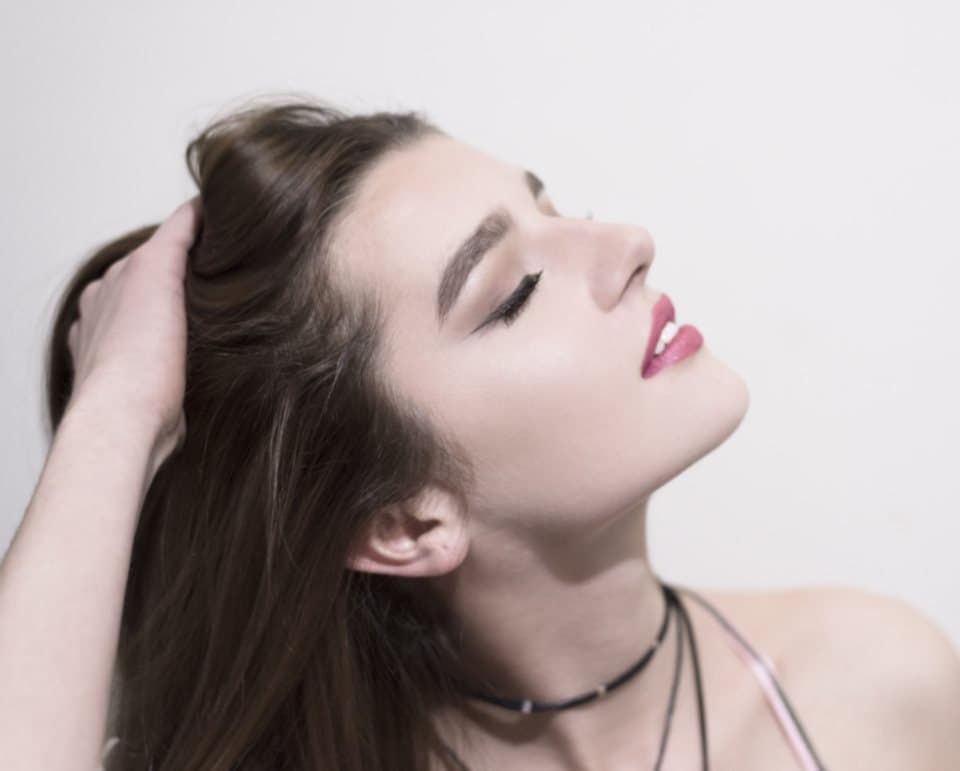 Woman running a hand through glossy dark hair